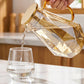 Eleganter, geometrisch geformter Glaskrug mit Teesieb